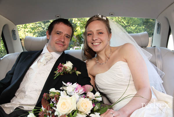 Bride and Groom in back of wedding car